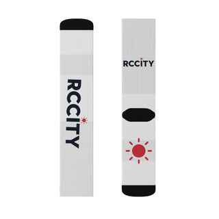 Two white socks with black and red branding on a white background